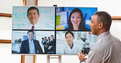 Un gruppo di persone che partecipano a una chiamata in videoconferenza in una sala riunioni moderna. 