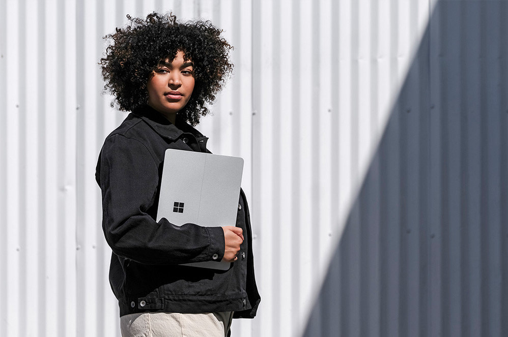 Una persona in piedi all'esterno con un dispositivo Surface Laptop Studio.