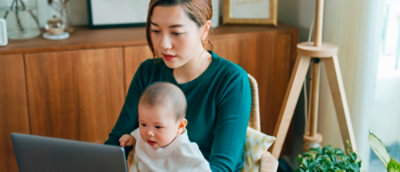 a woman and a kid looking at the laptop.
