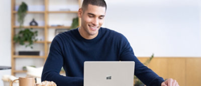 A person sitting at a desk looking at a laptop.