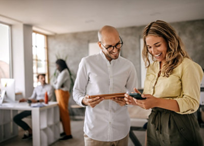 A man and woman looking at a tablet.