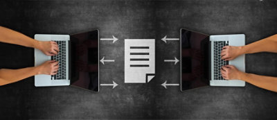 Due portatili con mani che digitano, uno davanti all'altro, con l'icona dei documenti tra loro e frecce che indicano dai portatili 