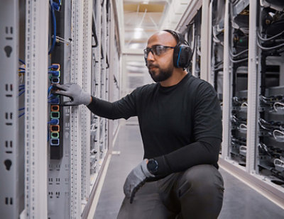 A man wearing headphones, gloves, and a black shirt with text 1000000=1 =.