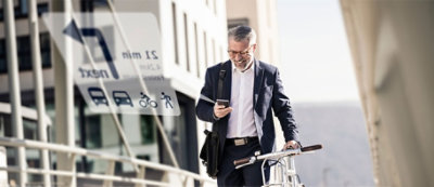 A person in a suit walking with a bicycle