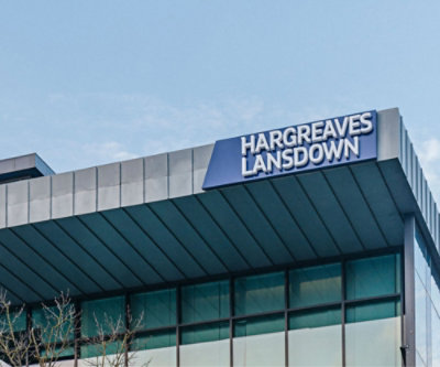 ป้าย “Hargreaves Lansdown” ที่ด้านบนของอาคารสมัยใหม่ที่มีท้องฟ้าใสในพื้นหลัง