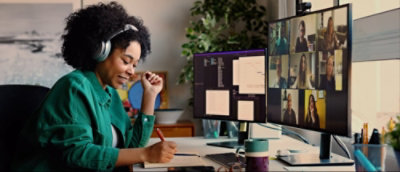 A person sitting at a desk with multiple computer screens