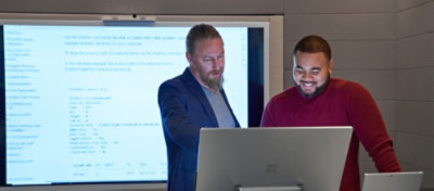 A group of men standing in front of a computer