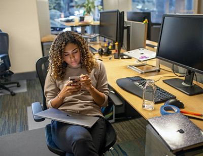 A woman with curly hair looking at her phone.