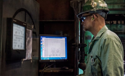 Tre personer i et kontormiljø: én tager noter, en anden skriver på et tastatur