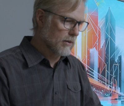 A close-up of a man wearing glasses and a black shirt.