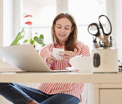 A slice of cheesecake with blueberries on a wooden plate.