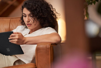 A person sitting on a couch holding a tablet.