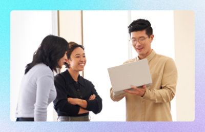 A group of people standing around a laptop.