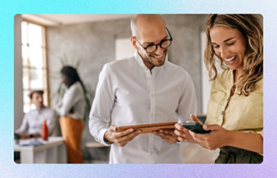A man and woman looking at a tablet.