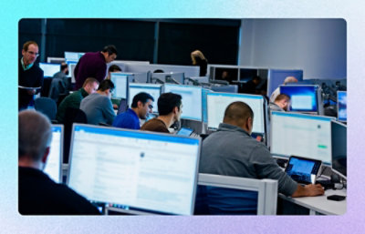 A group of people working on computers in a shared workspace.