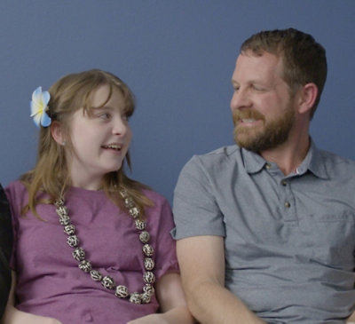  A father and daughter sitting and looking at each other smiling