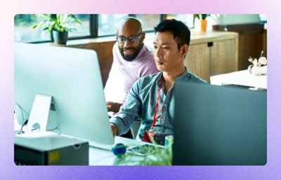 Two employees working on computer.