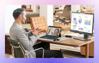 A man working on computer while also on video call on laptop.