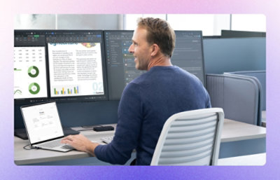 A man working on laptop and monitors.