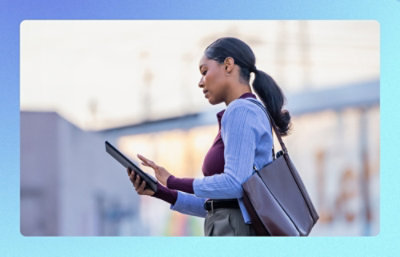 Person using a tablet while walking outdoors.