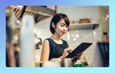 Person using a tablet in a café kitchen setting.