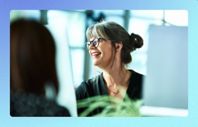 Two people talking in an office workspace.