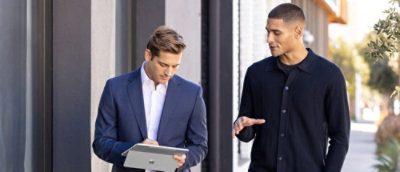 Two professionals reviewing notes outside an office