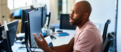 Person discussing work at a computer desk