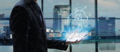 Una persona ha in mano l'elemento grafico digitale di una nuvola con dentro un lucchetto, che rappresenta la sicurezza del cloud.