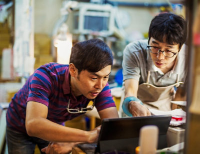 Two men are looking at laptop and discussing