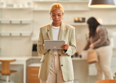A woman standing and using laptop.