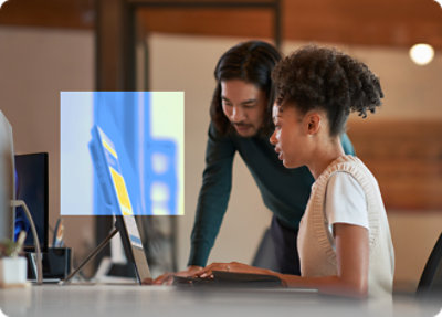 A man and woman looking at a laptop.
