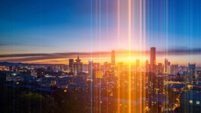 A city skyline with a sunset behind it.