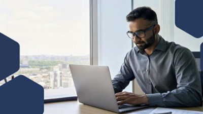 A person sitting at a desk typing on a laptop.