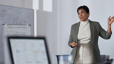 A person in a suit standing in front of a computer.