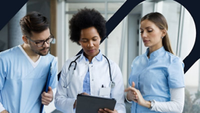 A group of medical professionals examining a clipboard.