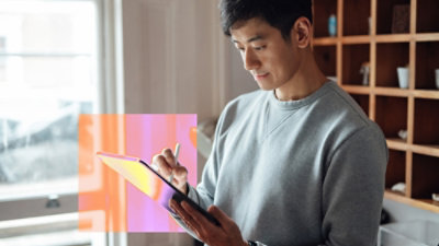 A man looking at the tablet in his hand.