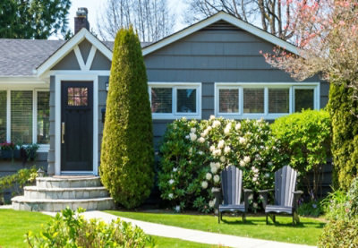 Et moderne hus med grønt græs og et træ.