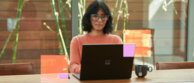 En kvinde med briller, der arbejder på en bærbar computer