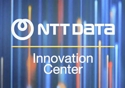 A close-up of a logo with the text NTT Data Innovation Center on a blue background.