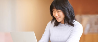 A woman is looking at the laptop.