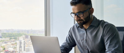 一位男士看着笔记本电脑。