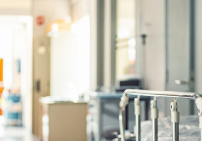 Bright hallway with metal railings and hospital‑style equipment in a clean, modern interior.