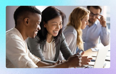 Team collaborating around a laptop during a meeting in an office setting