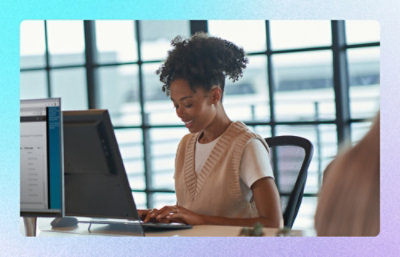Person working at a desktop computer in a bright office workspace