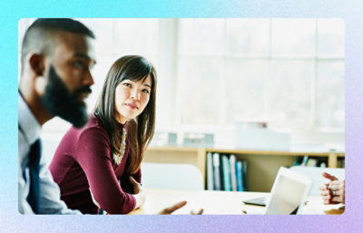 Colleagues in discussion around a table with laptop in a meeting room