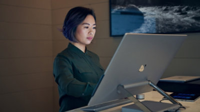 Person working on a laptop at a desk in an office environment
