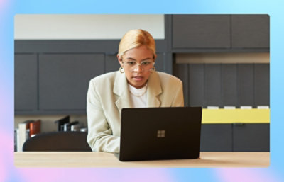 Una mujer con un traje blanco usando un portátil.
