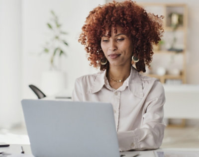 A person sitting at a desk using a laptop.
