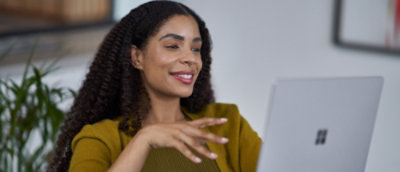 A girl smilling and looking into Laptop.